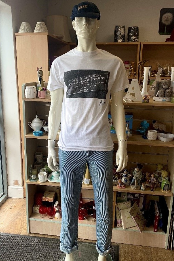 Mannequin dressed in white men's T-shirt and stripey trousers, with black baseball cap