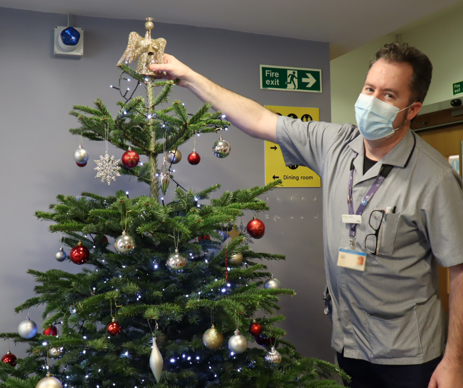 Rick Armstrong putting the angel on top of the Christmas tree